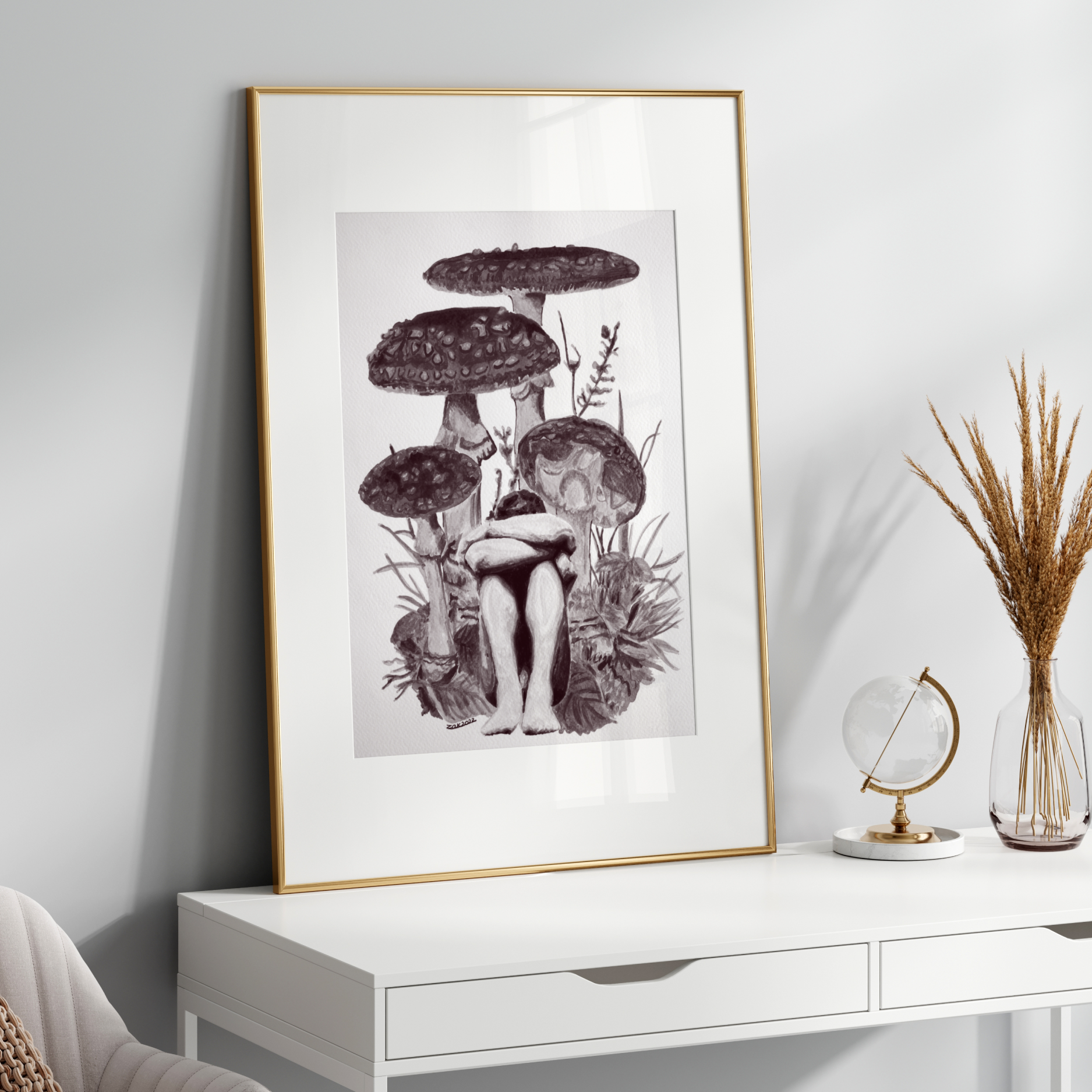Framed artwork of mushrooms on a white wall above a white console table.