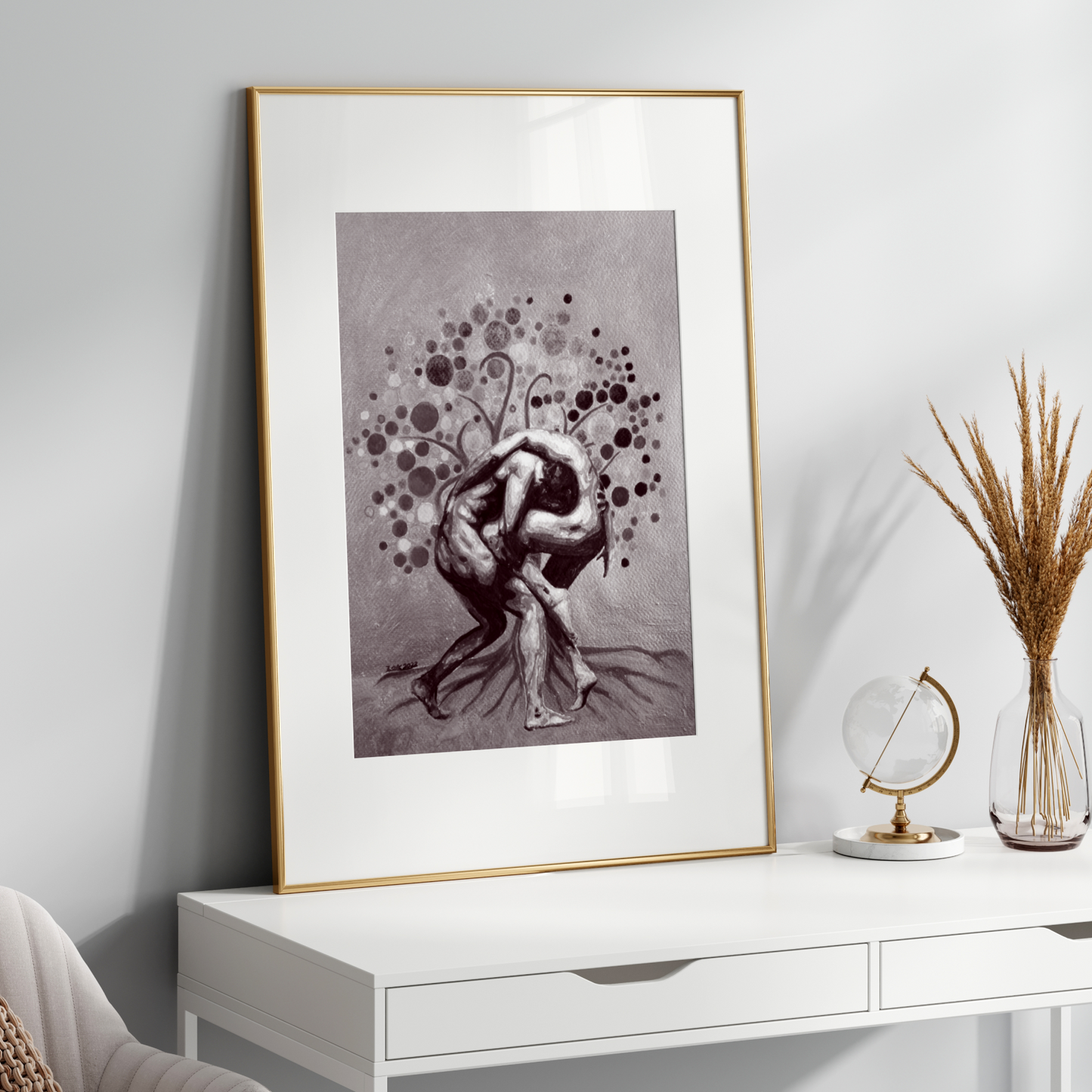 Framed black and white artwork on a white wall above a white console table.
