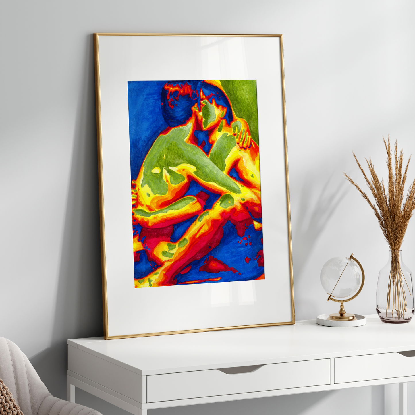 Colorful abstract art print in a gold frame on a white wall above a white desk.