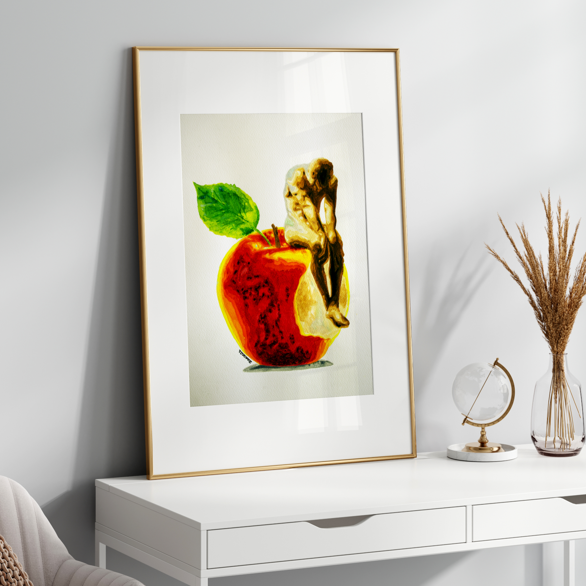 Framed artwork of a cherub with an apple on a white surface with decorative items.