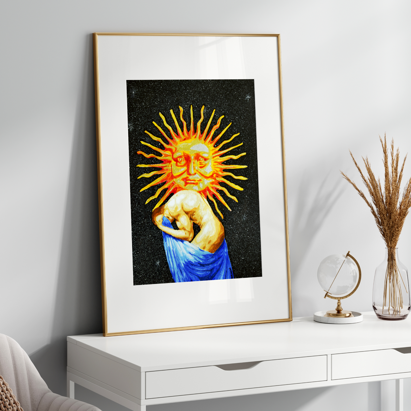 Framed artwork of a sun-like face on a white wall above a white console table.