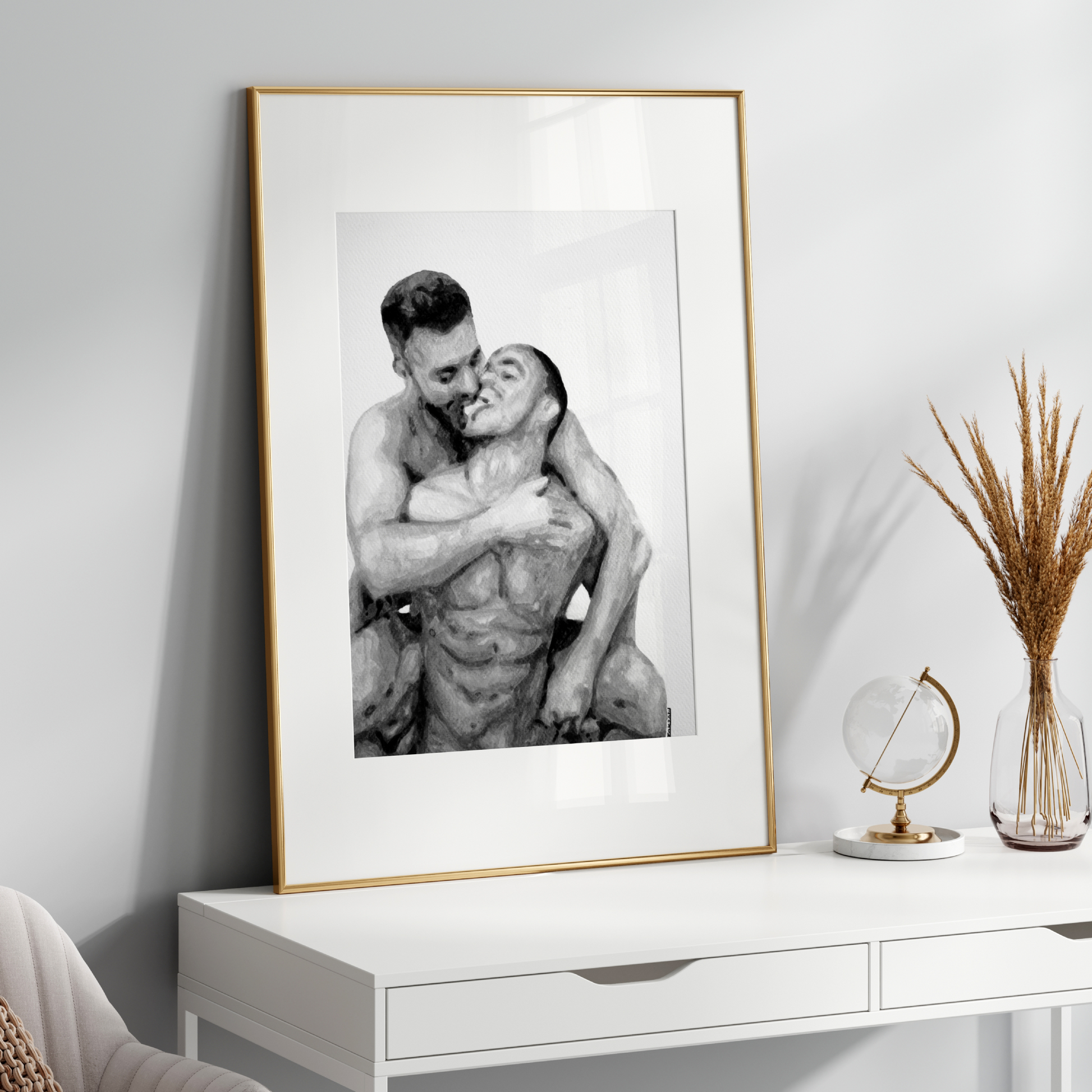 Framed black and white photograph of two people embracing on a white shelf with decorative items.