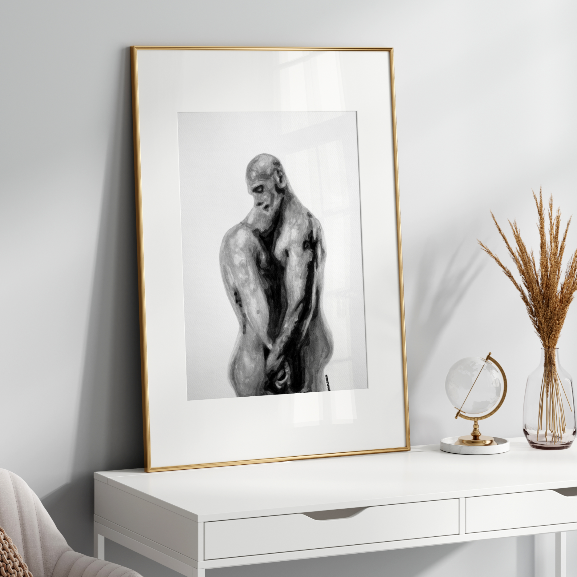 Framed black and white artwork of a nude figure on a white console table with decorative items.