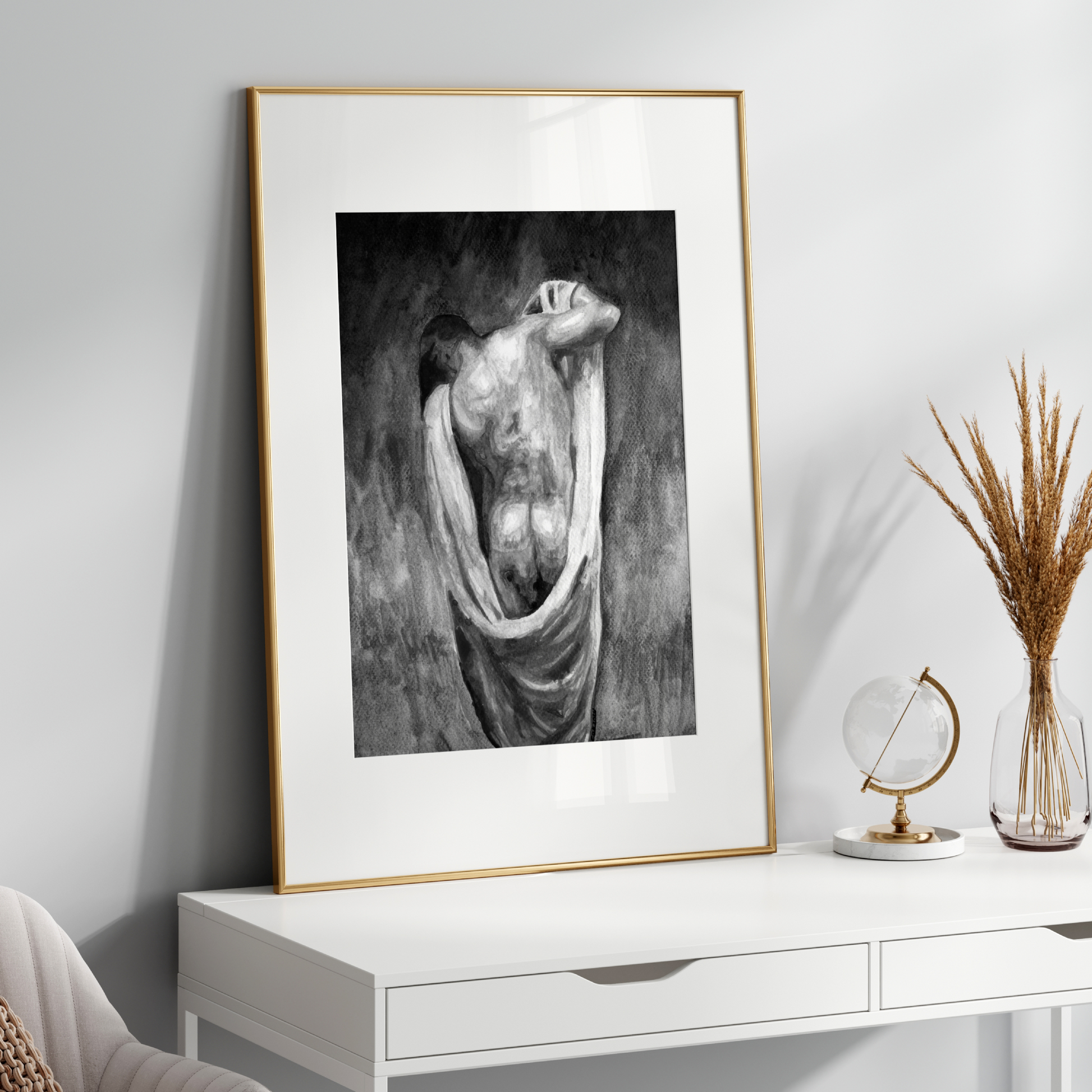 Framed black and white artwork on a white wall above a white console table.