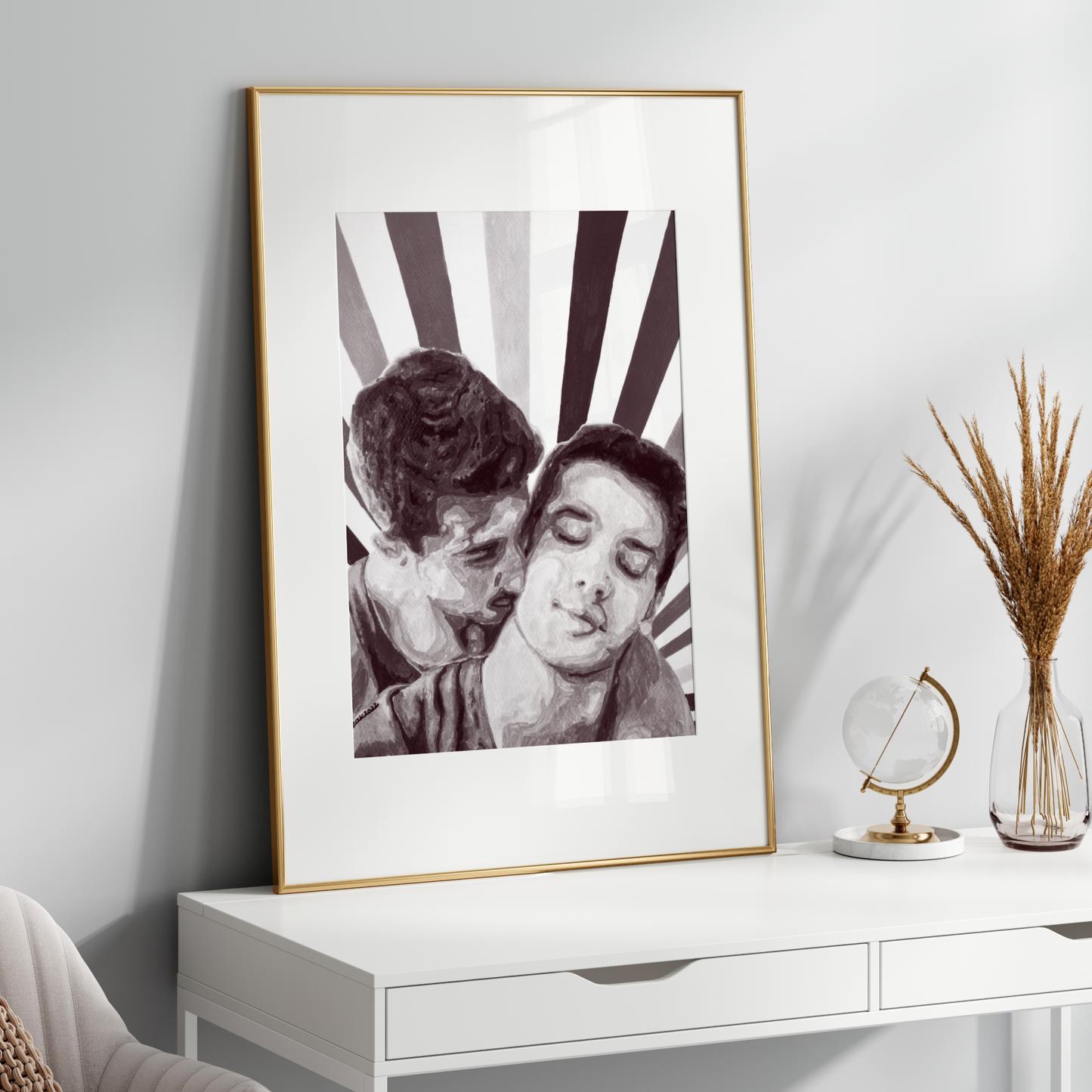 Framed black and white artwork on a white wall above a white console table with decorative items.