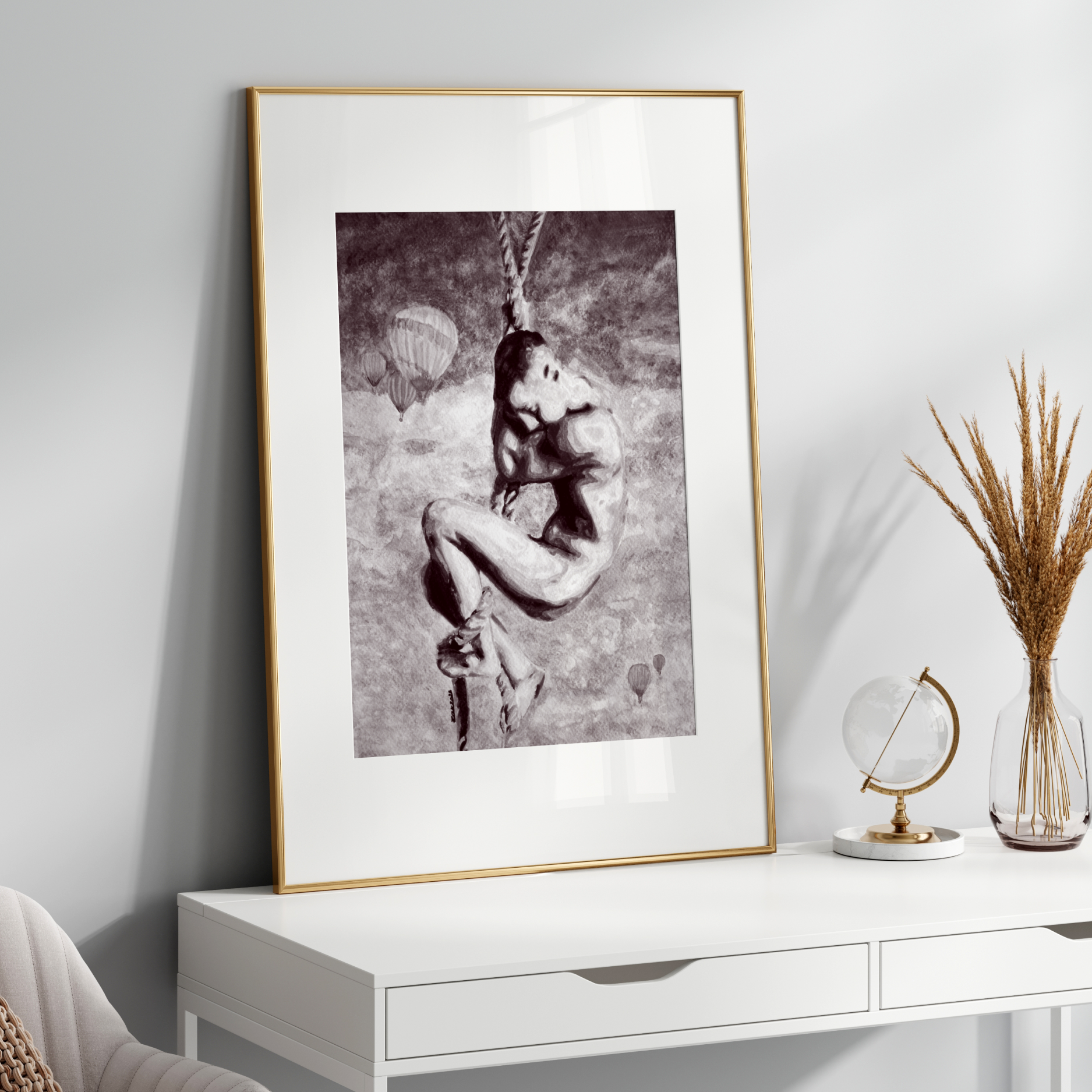 Framed black and white artwork on a white wall above a white console table with decorative items.