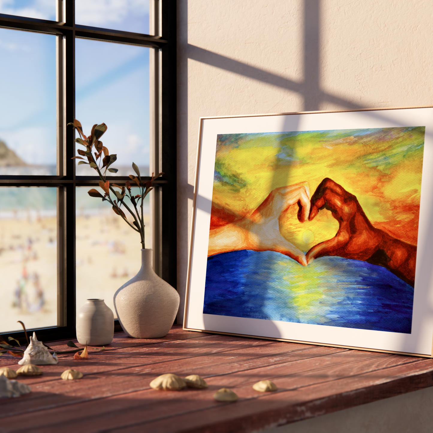 Framed artwork of hands making a heart shape over water on a windowsill with a scenic view outside.