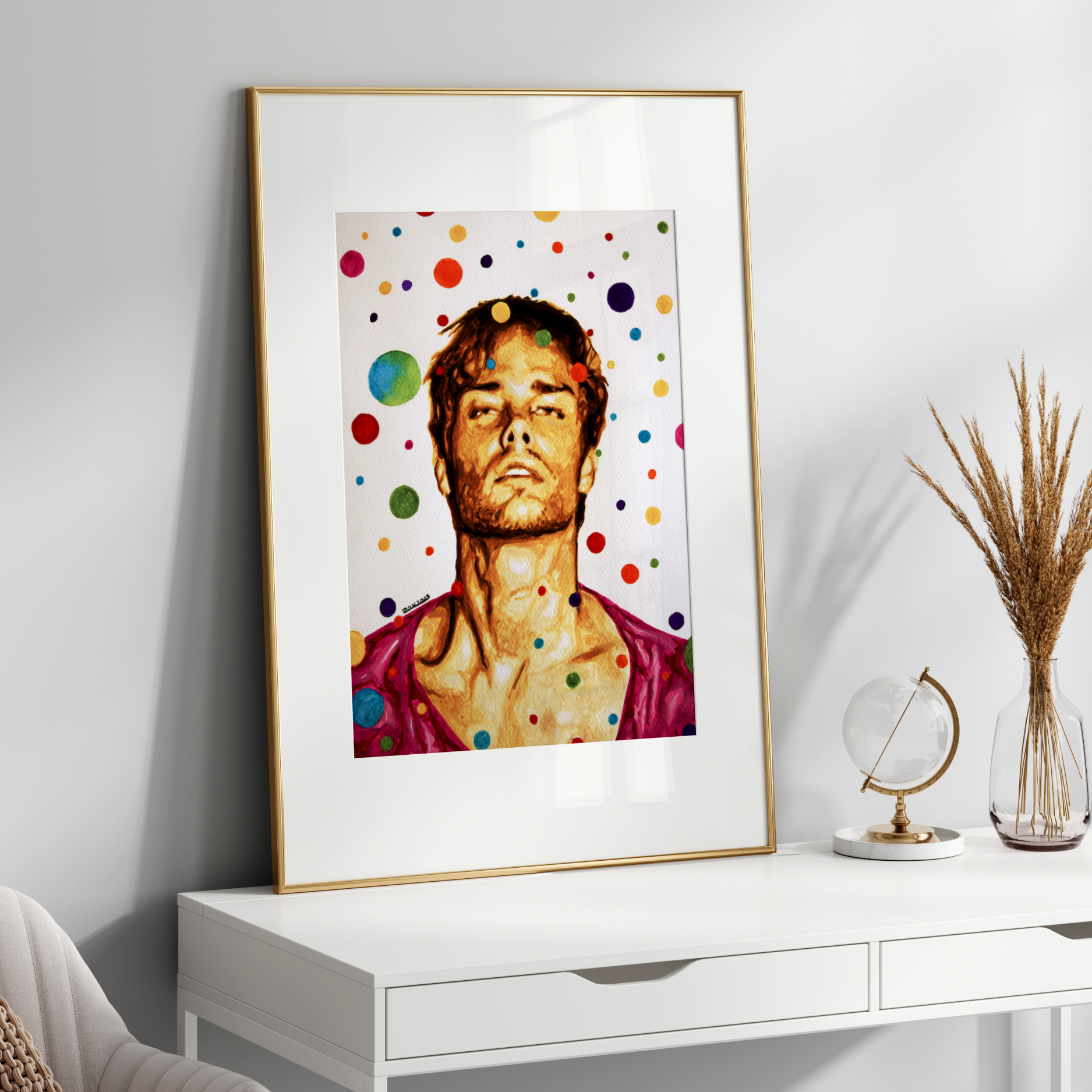 Framed artwork of a person with colorful polka dots on a white wall above a white console table.