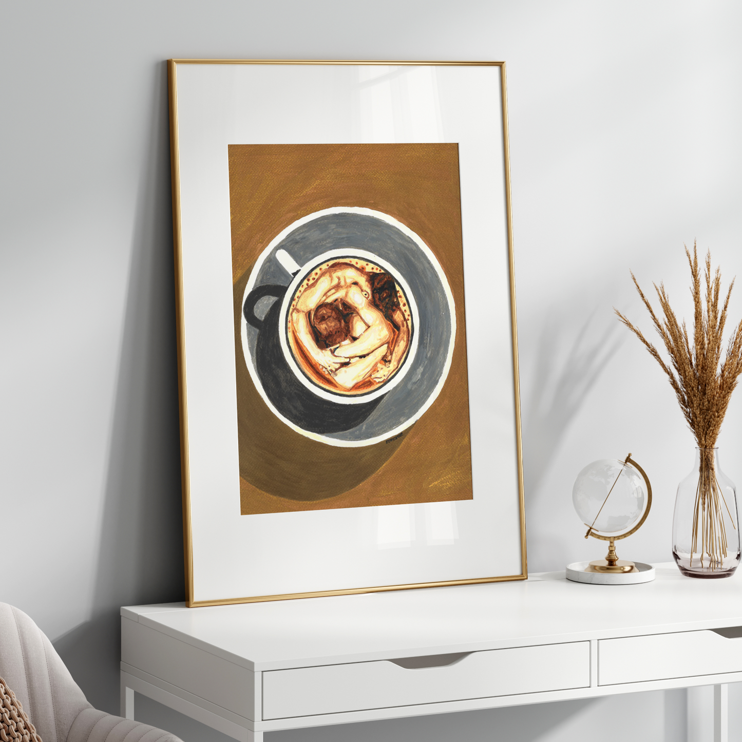 Framed artwork of a coffee cup on a white surface with decorative items.