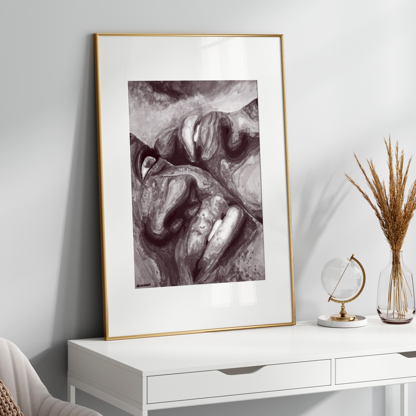 Framed black and white artwork on a white wall above a white console table.