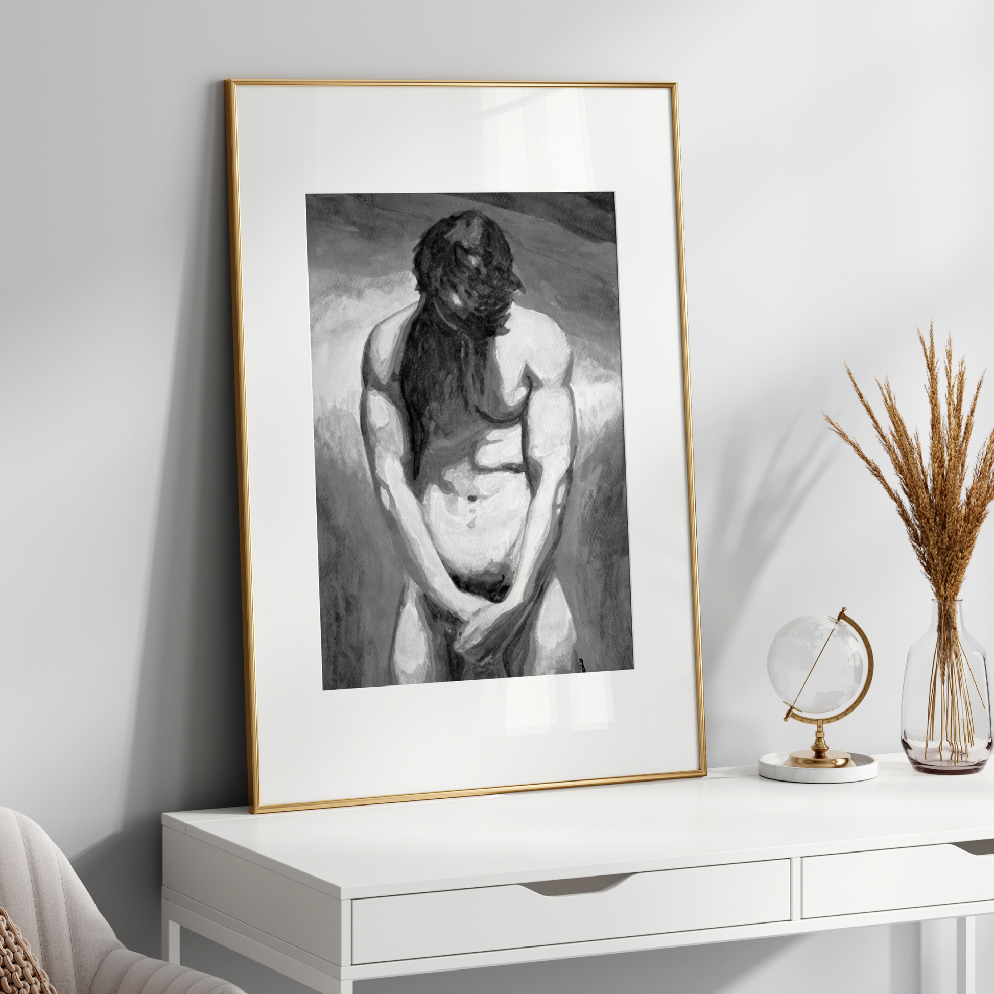 Framed black and white artwork on a white wall above a white console table with decorative items.