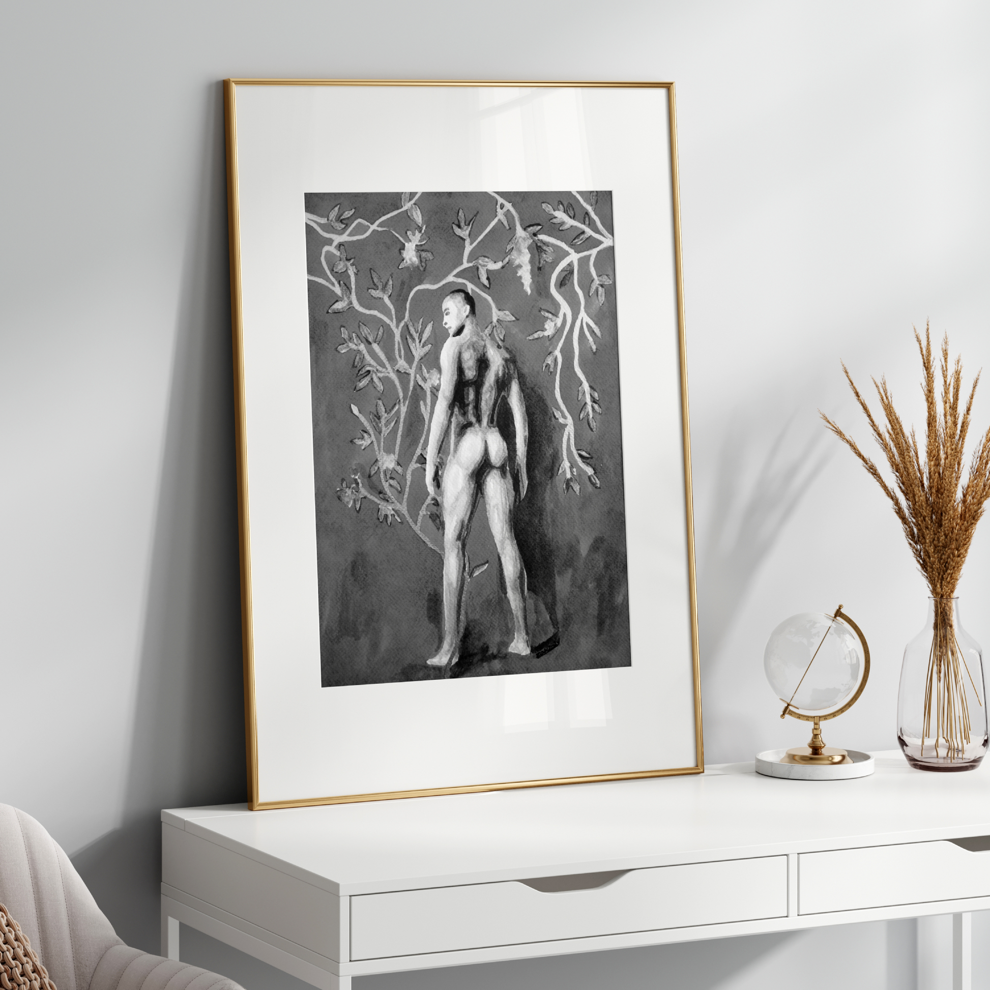 Framed black and white artwork on a white wall above a white console table with decorative items.