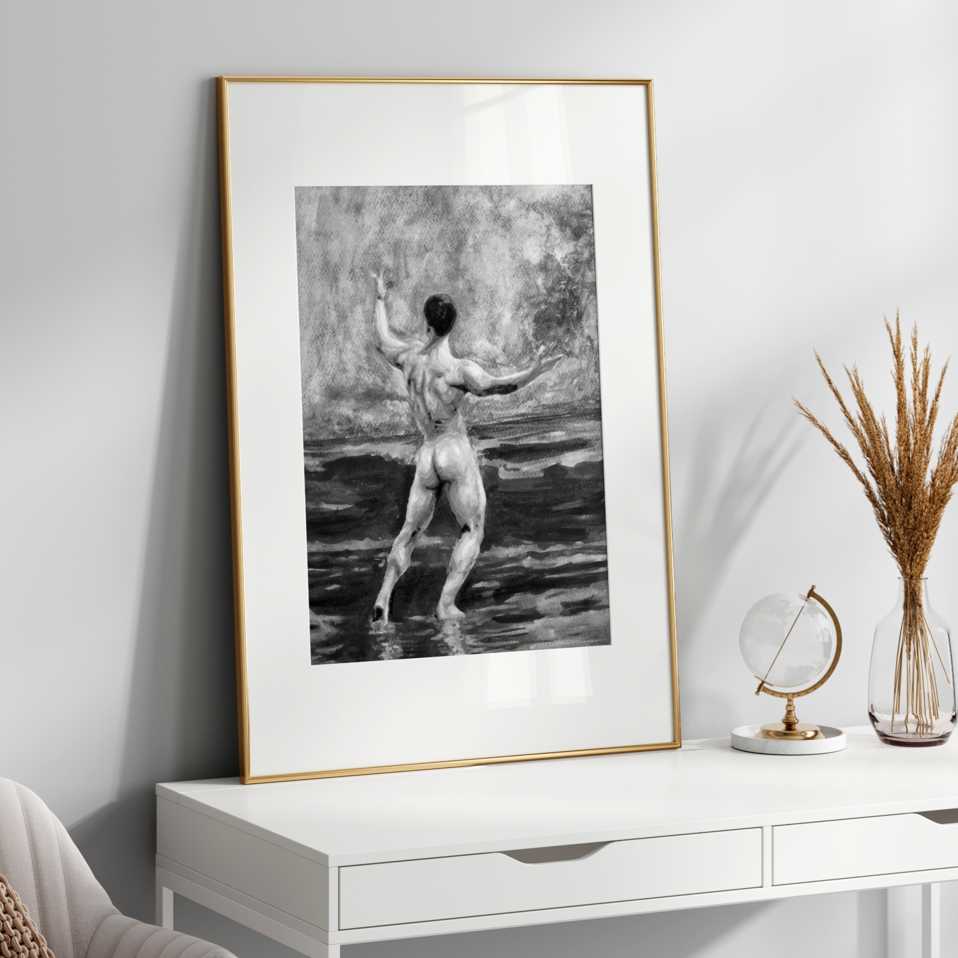 Framed black and white artwork of a nude figure on a white wall above a white console table.