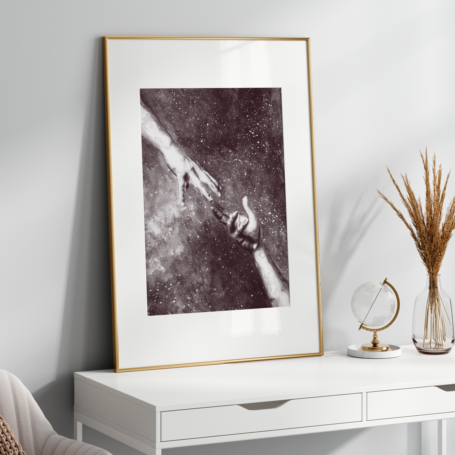 Framed artwork on a white wall above a white console table with decorative items.