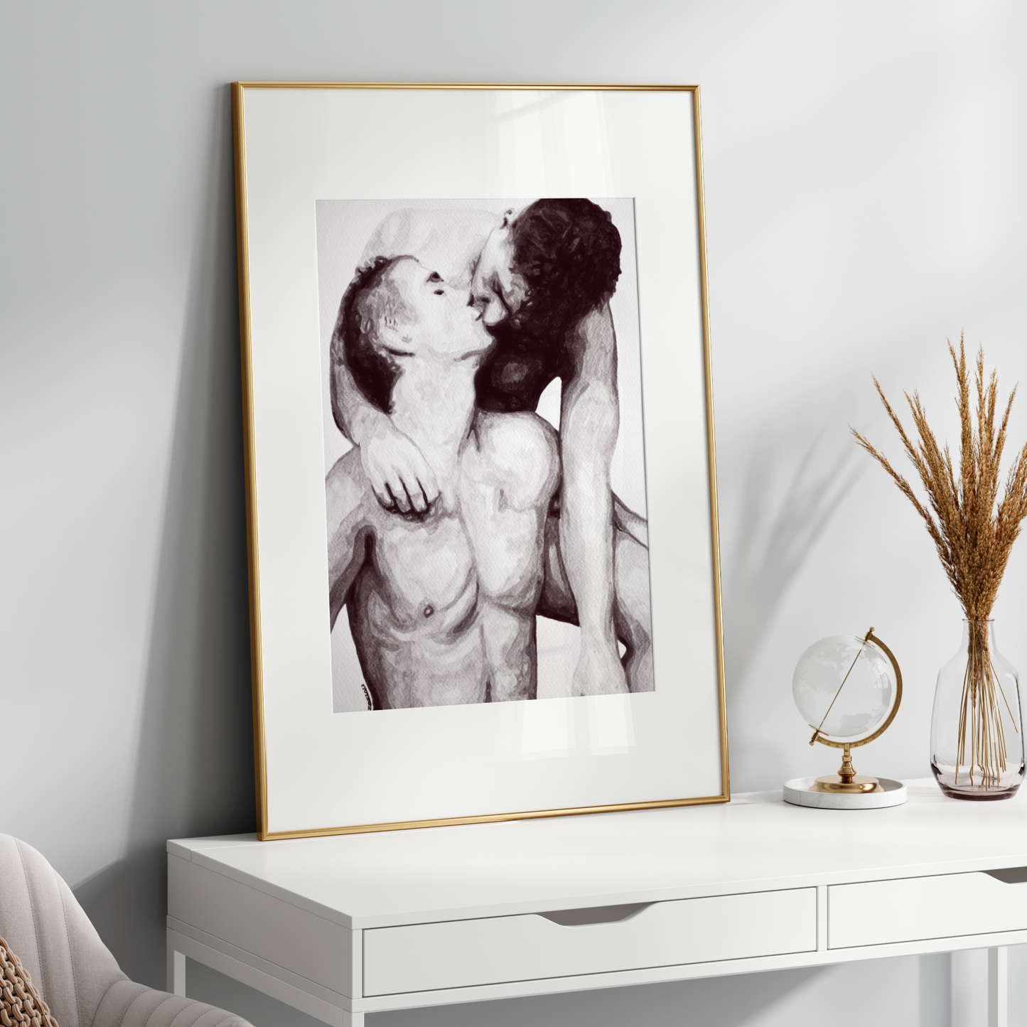Framed black and white artwork of two people embracing on a white shelf with decorative items.