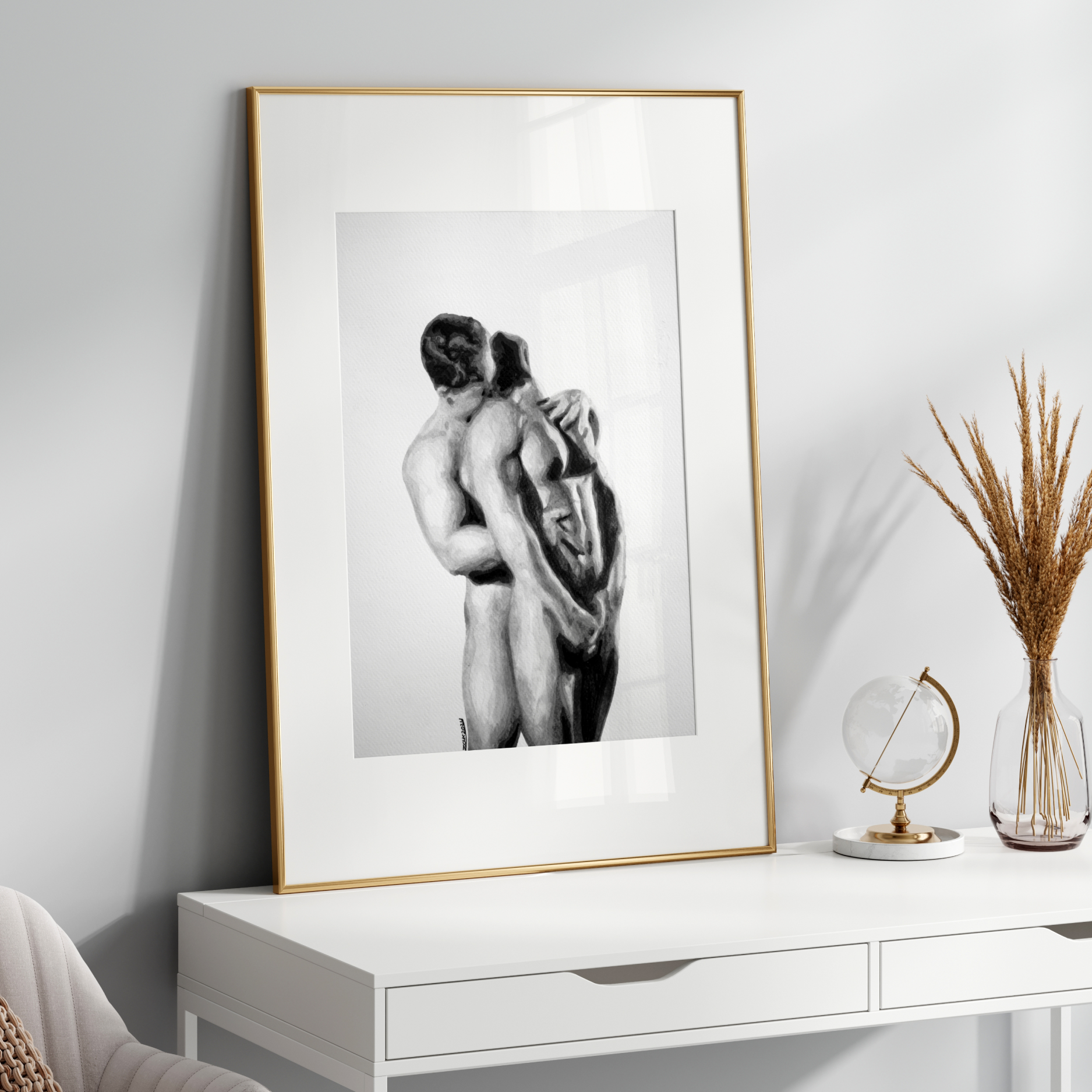 Framed black and white artwork of two people embracing on a white wall above a white console table.