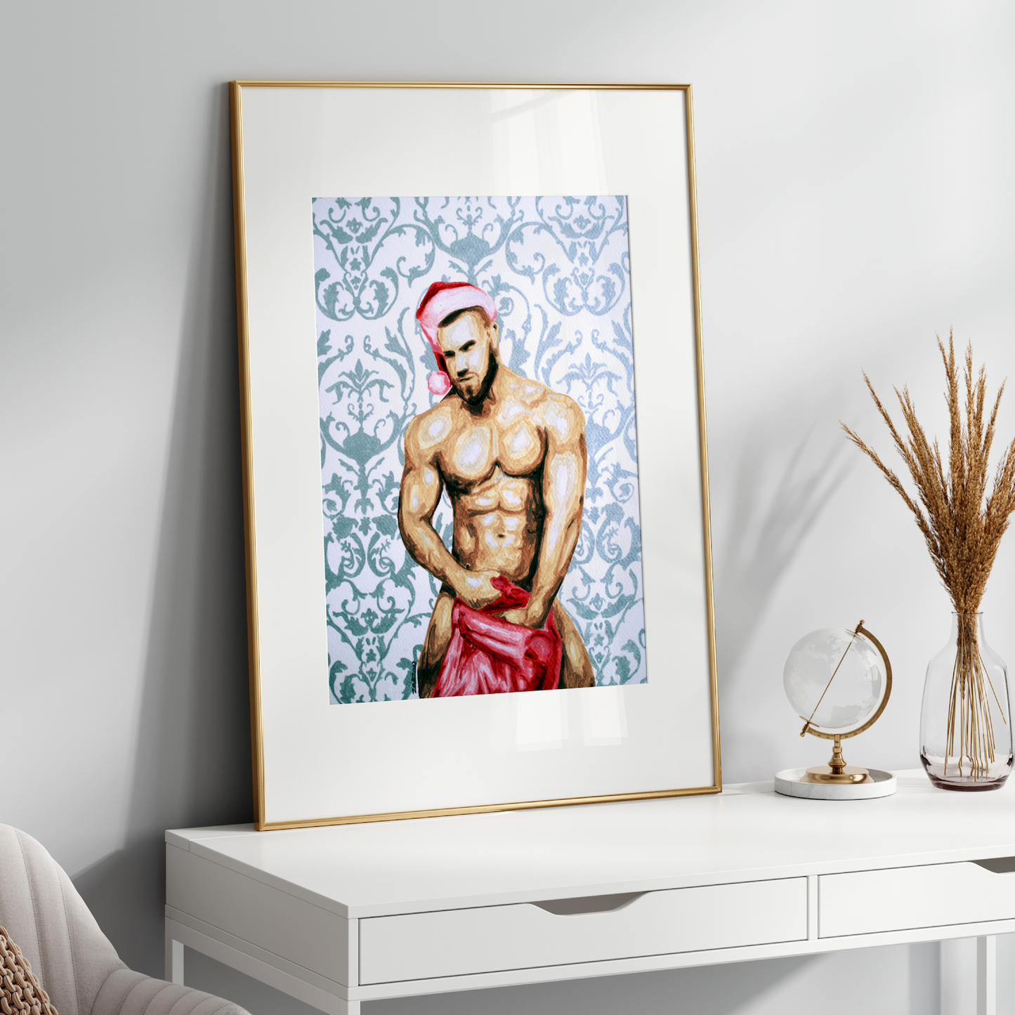 Framed artwork of a shirtless man with a red garment on a white shelf.