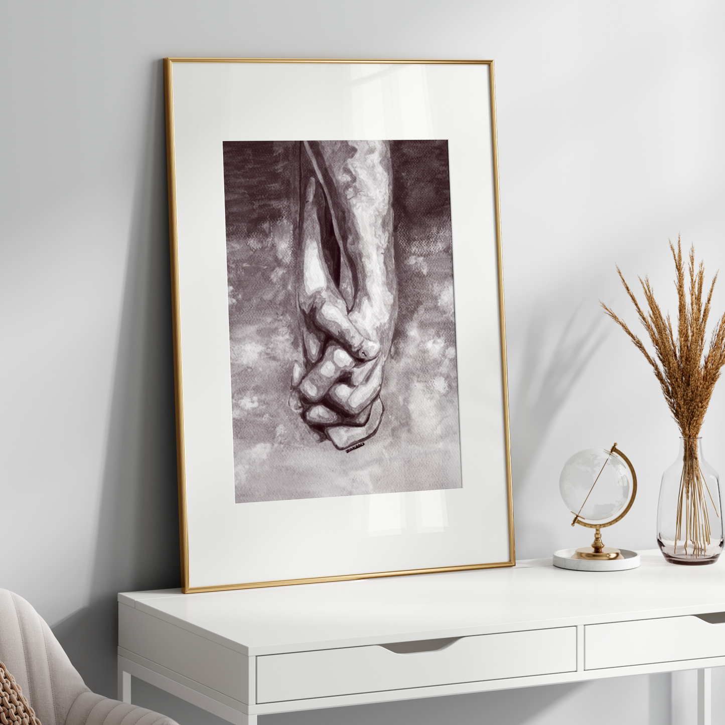 Framed black and white artwork on a white wall above a white console table.