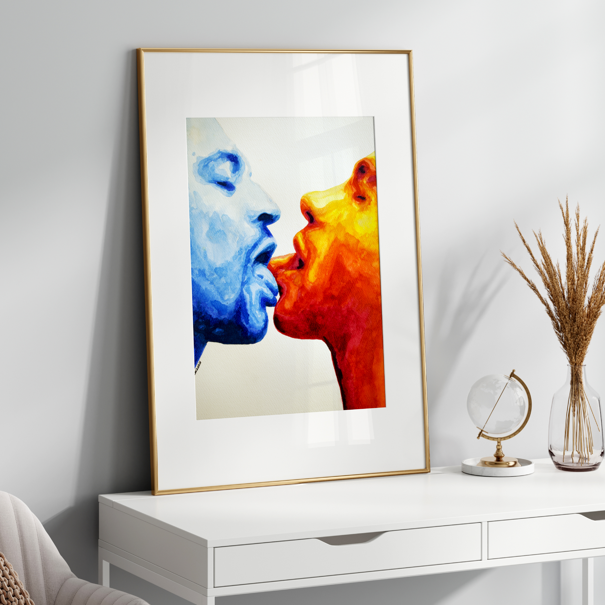Framed abstract art of two faces in blue and orange on a white wall above a white console table.