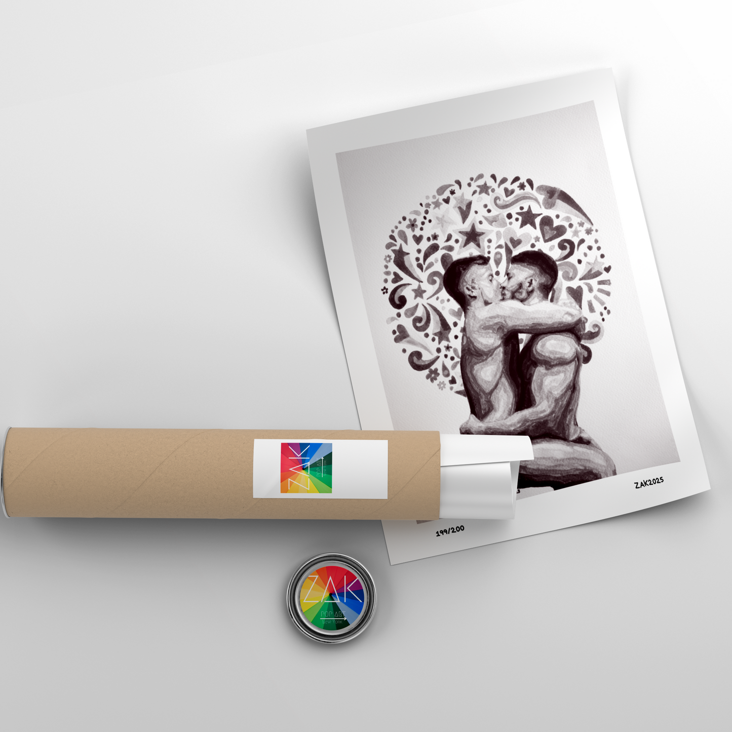 Artistic print of two figures embracing with decorative elements, placed on a white surface with a cylindrical object and colorful label.