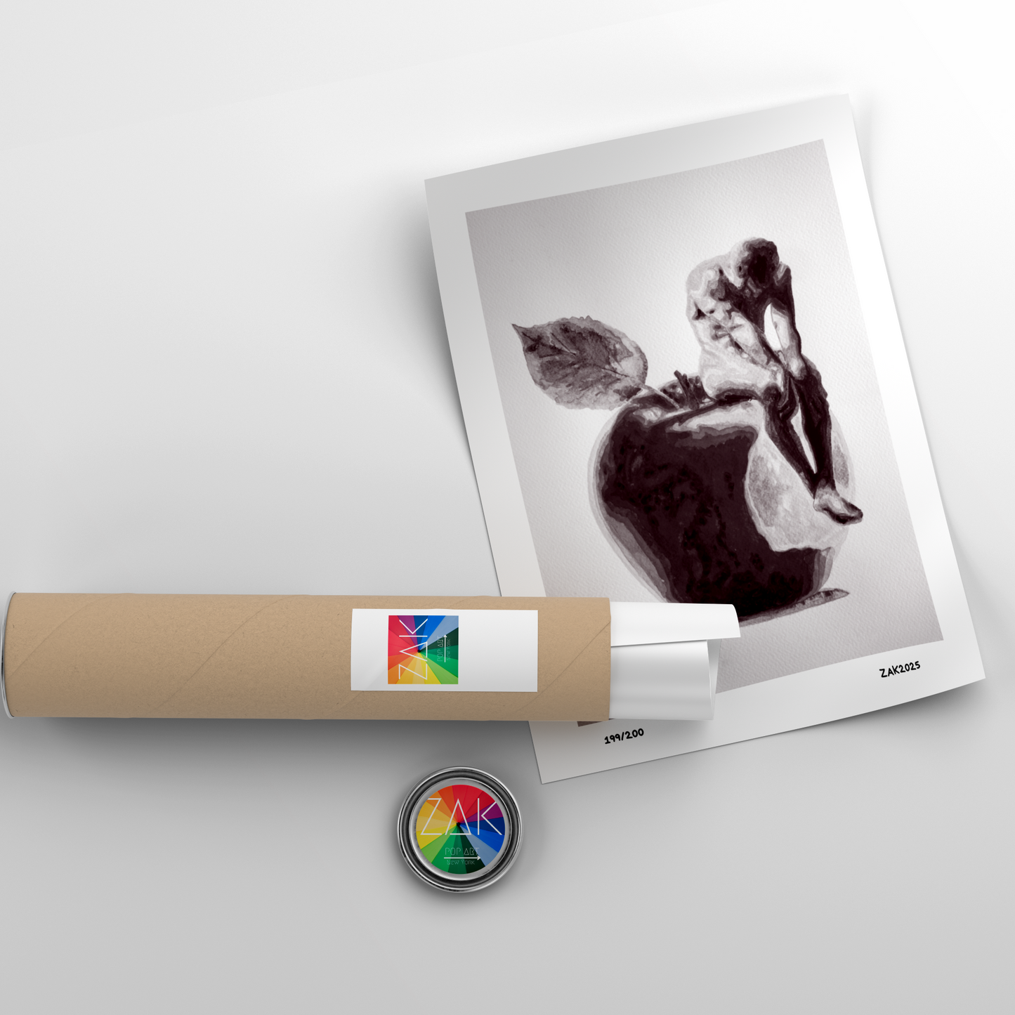 Roll of paper with a colorful label, a framed black and white photo, and a round object on a light gray background.