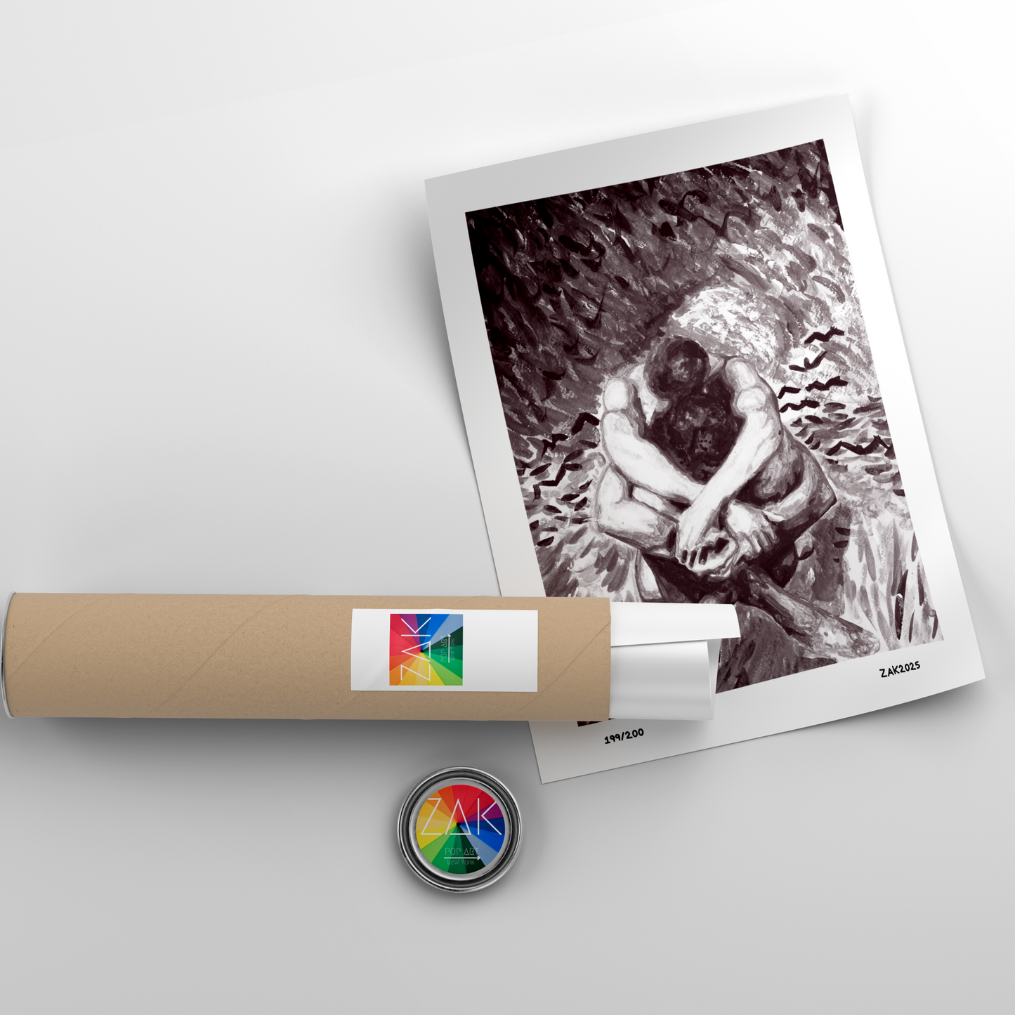 Framed black and white photo of a couple embracing, with a roll of film and a lens cap on a light gray background.