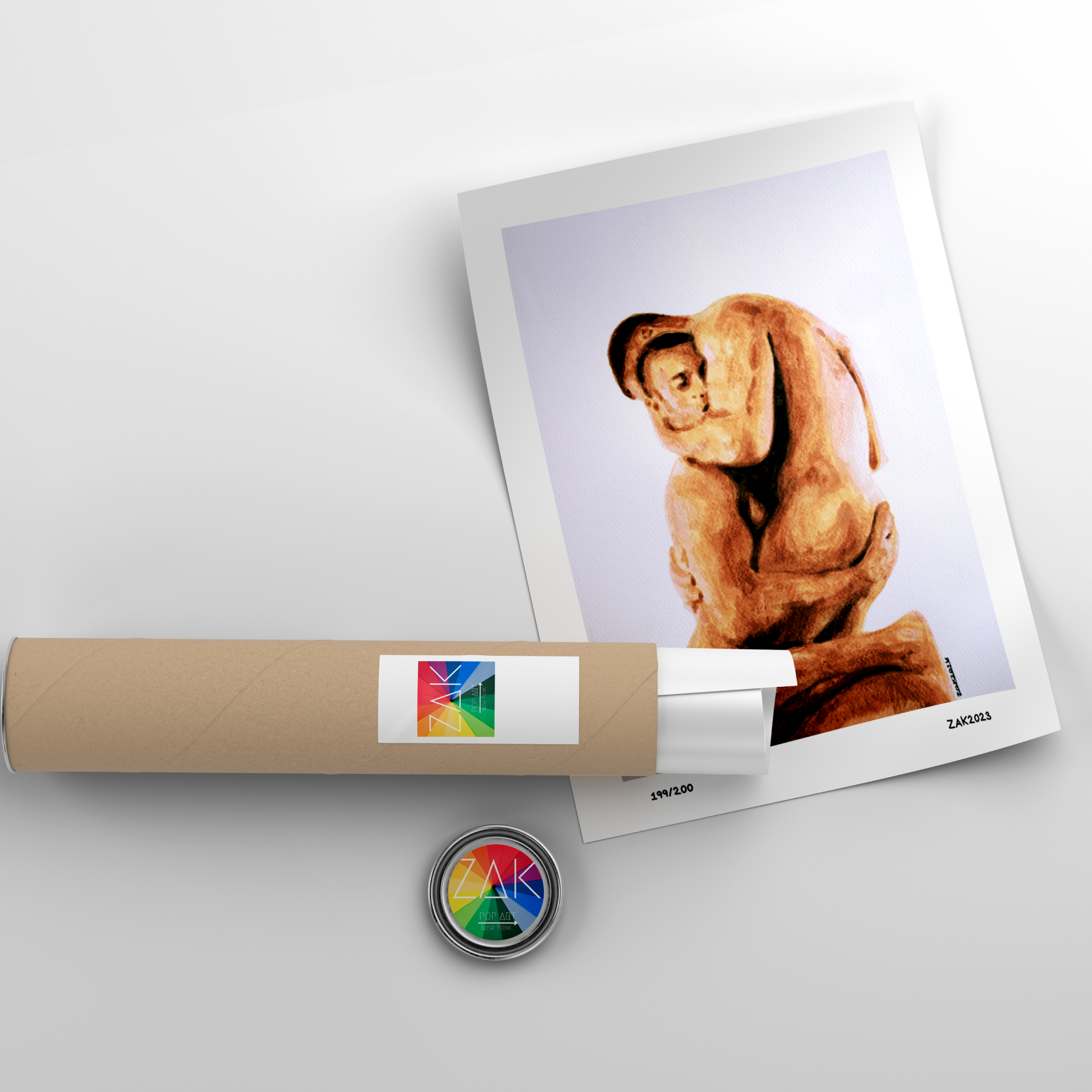 Rolled-up poster with a printed image of a person, a small round object with a colorful design, and a white surface.